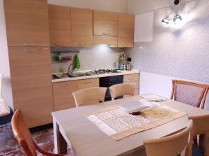 a kitchen with a table with chairs and a stove at Casa Nives in Villa Emilia in Vietri sul Mare