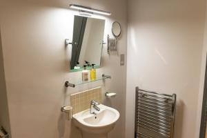 
a bathroom with a sink and a mirror at Albert Arms in Esher
