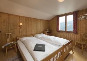 a bedroom with a bed with a book on it at Chalet Ritornell in Wildhaus