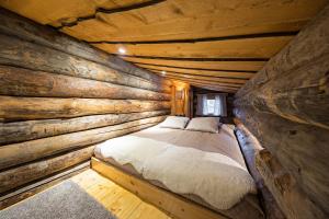 a bed in a log cabin bedroom at UnelmaKaukelo in Ruka