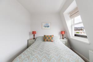 a bedroom with a bed and two windows at JOIVY Cosy 1 bed flat with balcony in Pimlico, next to Warwick Square in London