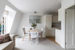 una cucina e una sala da pranzo con tavolo e sedie di JOIVY Cosy 1 bed flat with balcony in Pimlico, next to Warwick Square a Londra