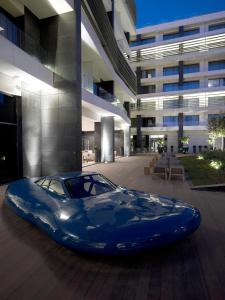 a blue car parked in front of a building at The Met Hotel Thessaloniki, a Member of Design Hotels in Thessaloniki