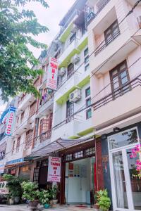 a tall white building with signs on it at Thanh An 2 Guesthouse in Hue