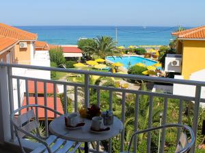 un balcone con tavolo, sedie e piscina di Paspalis Hotel a Skala di Cefalonia