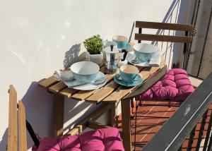 un tavolo in legno con tazze e piattini sul balcone di Studio Sant'Antonio a Pizzo