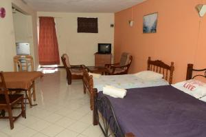a bedroom with two beds and a table and chairs at Dookee House in Grand Baie