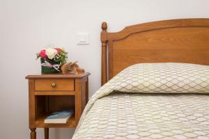 a bedroom with a bed and a nightstand with a flower arrangement at Villa Médicis Trouville-sur-mer in Trouville-sur-Mer