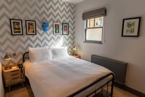 Un dormitorio con una cama blanca grande y una ventana en Albert Arms, en Esher 66 fotos más