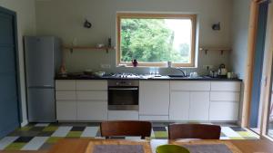 Penvénanにあるinvitation au rivageのキッチン(冷蔵庫付)、窓が備わります。
