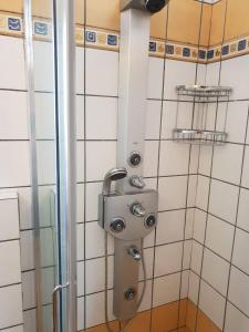 a shower in a bathroom with white tiles at Pallas Casa in Panagía