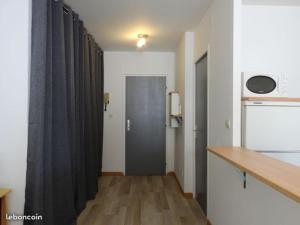 a kitchen with a hallway with black curtains and a counter at Le Saint Antoine in Saint-Jean-de-Maurienne