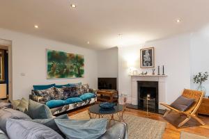a living room with a couch and a fireplace at Lovely 2 bedroom flat in Chelsea, sleeps 4 in London
