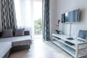 sala de estar con sofá y TV en Rental Apartments Krochmalna en Varsovia