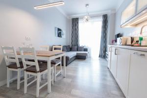 een keuken en een woonkamer met een tafel en een bank bij Rental Apartments Krochmalna in Warschau