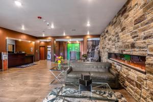 a living room with a couch and a brick wall at Cobblestone Hotel & Suites Hartford in Hartford