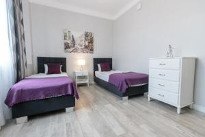 ワルシャワにあるRental Apartments Krochmalnaのベッドルーム1室(ベッド2台、ドレッサー付)