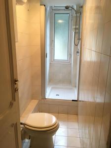 een badkamer met een toilet en een douche met een raam bij La Casa di Sara in Genua