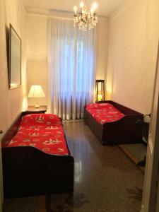 een slaapkamer met 2 bedden en een kroonluchter bij La Casa di Sara in Genua
