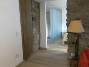 una sala de estar con una pared de piedra y una lámpara. en Pensió i Apartaments la Bordeta en Taüll