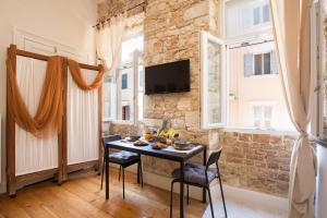 a dining room with a table and chairs and a brick wall at Kamara House in Corfu