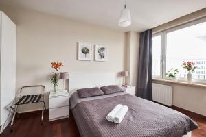 a bedroom with a bed with two towels on it at Top Ten House Marszałkowska II in Warsaw