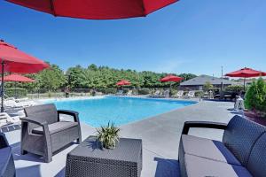 a swimming pool with chairs and umbrellas at Blue Creek Inn in Waretown
