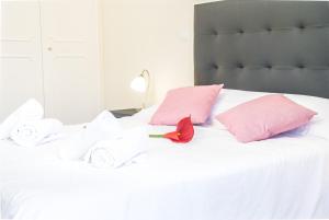 uma cama branca com toalhas e uma rosa vermelha em Arcadas Cozy Apartments - AV no Funchal