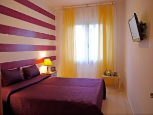 a bedroom with a red bed and a striped wall at Hotel Germania in Lido di Jesolo