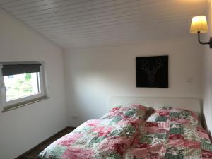 a bedroom with a bed with a quilt on it at Casa Müller in Lissendorf