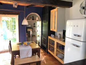 uma cozinha com uma mesa e um frigorífico em Casa rural De Añil - Jardín privado, wifi, netflix y aire acondicionado em Velliza