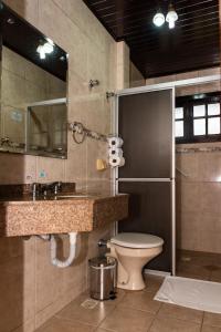 een badkamer met een toilet, een wastafel en een spiegel bij Filadélfia Hospedagens e Eventos in São Bento do Sul