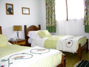 1 dormitorio con 2 camas y ventana en Hostería Pampa Linda en San Carlos de Bariloche