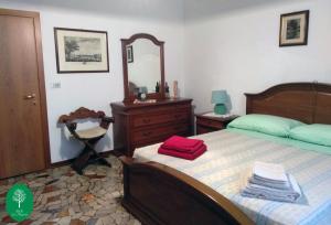 een slaapkamer met een bed, een dressoir en een spiegel bij B&B La Magnolia in Creazzo