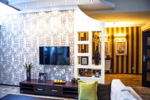 a living room with a couch and a tv on a wall at "Staromiejskie" in Zamość