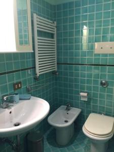 Baño de azulejos verdes con lavabo y aseo en Montecchio, en Padua