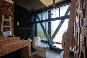 a bathroom with a white toilet and a window at Manulodge Matanzas in Matanzas