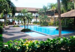 uma piscina com palmeiras num resort em Residências Garcez, paraíso à beira da praia Enseada, Guarujá no Guarujá