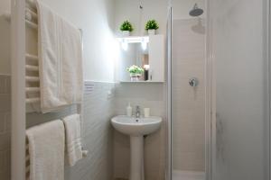 a white bathroom with a sink and a shower at House Bonifacio in Rome