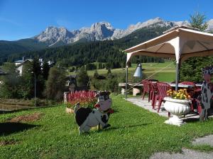 une statue d'une vache dans l'herbe près d'une table dans l'établissement Residence La Pineta, à Padola