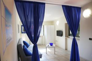 ナポリにあるMomento Napoletanoのリビングルーム(青いカーテン、ソファ付)