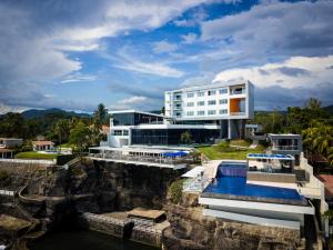 a building with a swimming pool next to a body of water at Acantilados in La Libertad