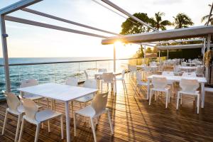 um restaurante com mesas brancas e cadeiras num deque em Acantilados em La Libertad