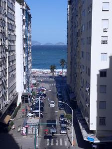 Blick auf eine Stadtstraße mit Gebäuden und das Meer in der Unterkunft Loft em Copacabana Posto 6 in Rio de Janeiro