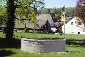 a monument in a field with two flags and two horses at Casa Ledara Baumberge in Billerbeck