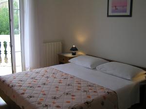 1 dormitorio con 1 cama con manta blanca y ventana en Apartments Paloma Blanca, en Medulin