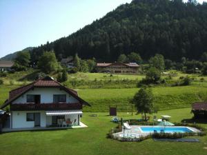 a house and a swimming pool in a field at Ferienwohnungen Kaiser in Gallizien