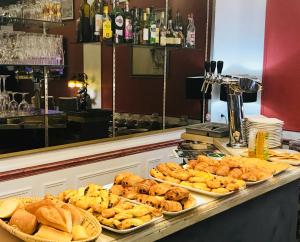 a buffet with different types of bread and pastries at Hôtel Crystal Reims Centre in Reims