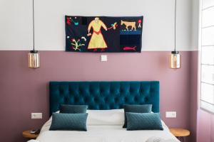 a bedroom with a bed, a desk, and a painting on the wall at Neratzia Rooms in Athens