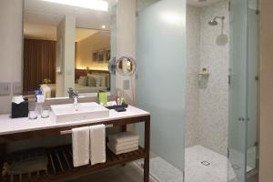 a bathroom with a shower, sink, and mirror at Emporio Cancun in Cancún